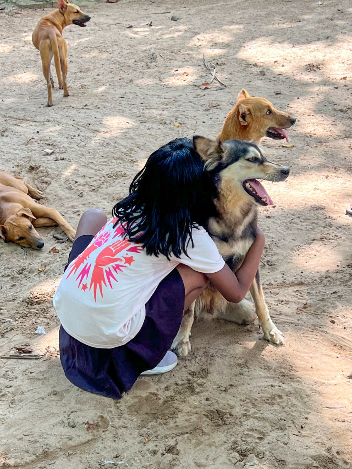 Kind von hinten im dogvanture Buddy Shirt umarmt Hund